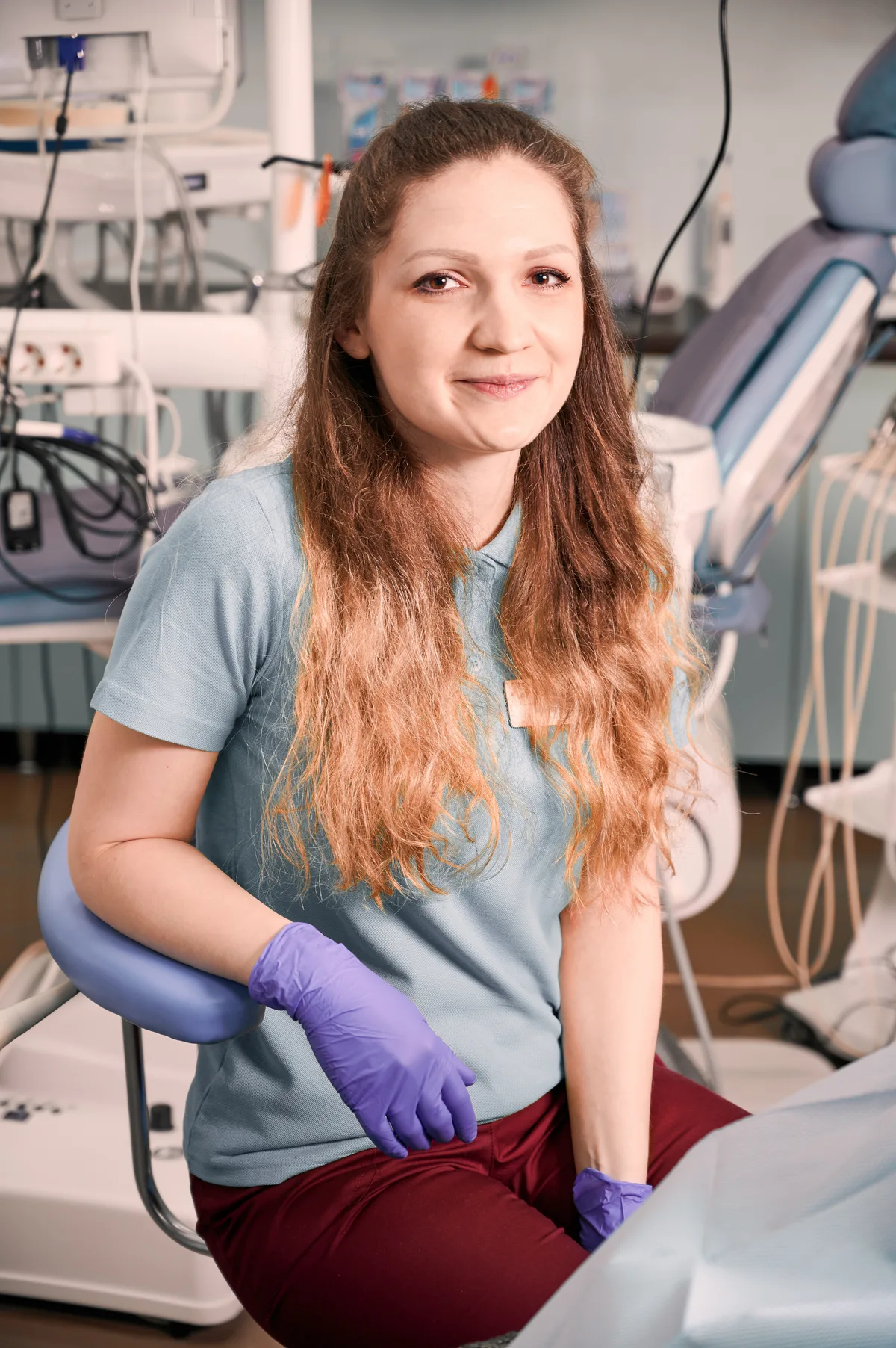 Dr. Marie Anderson sitting beside a dental chair