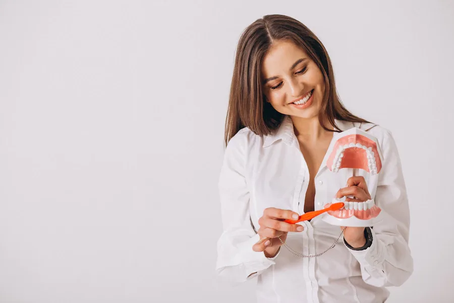 Patient holding a model of teeth and a toothbrush