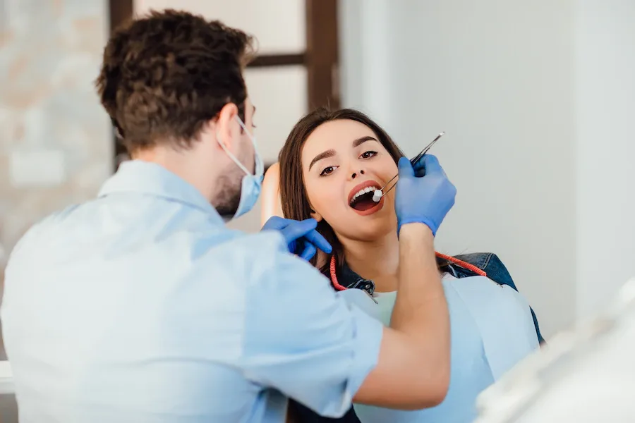 Orthodontist examining a smiling patient