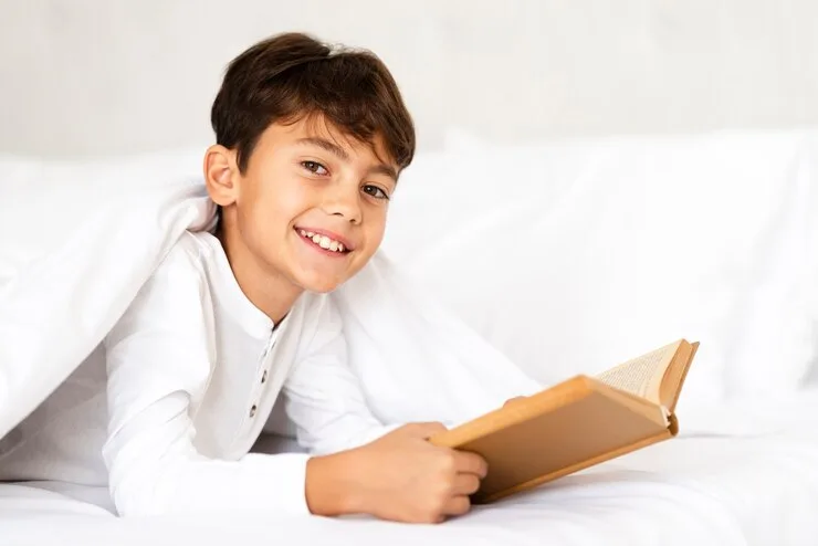 Smiling boy reading a book